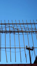 Low angle view of antenna against clear blue sky