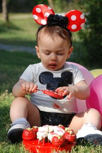 Baby eating cake while sitting at park