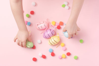 High angle view of woman with easter egg over pink background