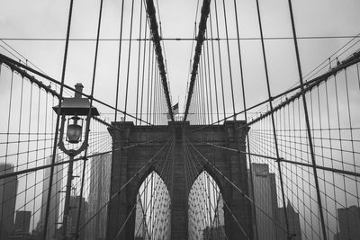 Low angle view of suspension bridge against sky