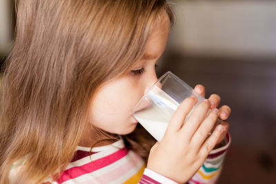 Side view of girl drinking mill