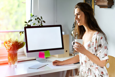 Smiling woman looking away while working at home