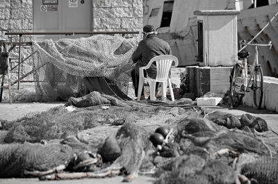 Man sitting on chair at harbor