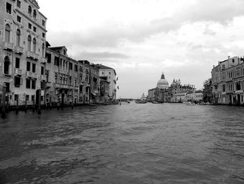 View of buildings by sea against cloudy sky