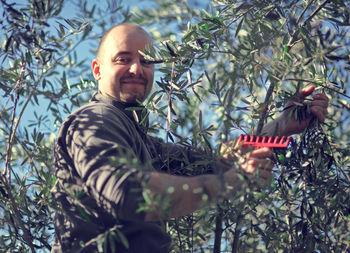 Portrait of man working at tree