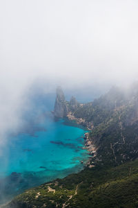 High angle view of sea and mountains against sky