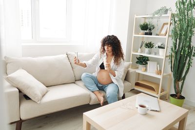 Young woman sitting on sofa at home