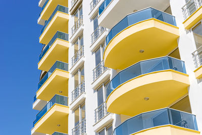 Yellow and blue modern ventilated facade with windows.