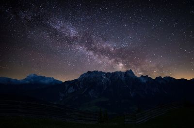 Scenic view of mountains against star field in sky at night