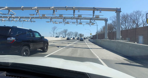 Cars on road against sky in city