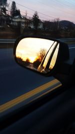 Reflection of trees in side-view mirror