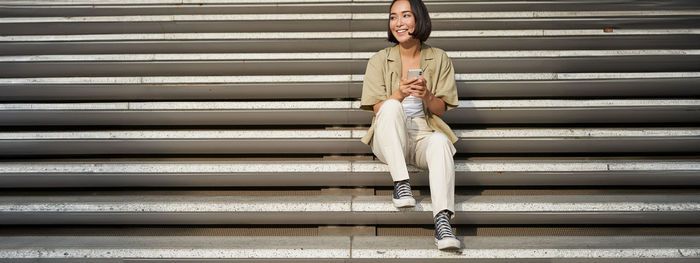 Full length of woman standing against wall