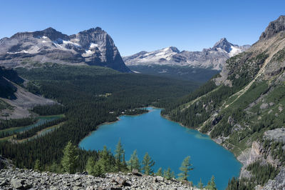 Scenic view of lake and mountains against clear blue sky