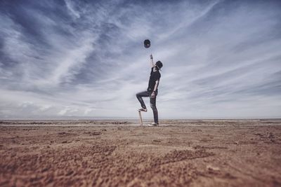 Side view of man standing on land against sky