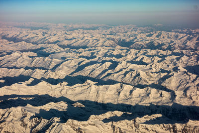 Aerial view of snowcapped mountains against sky