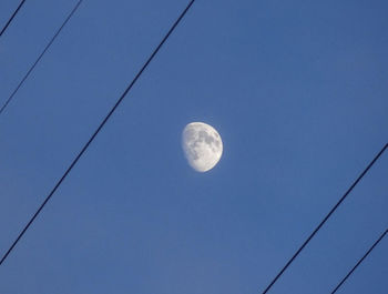 Low angle view of moon against blue sky