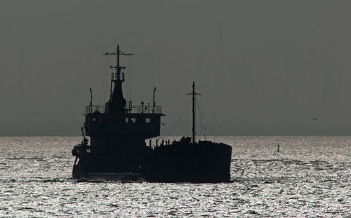 Ship sailing in sea against clear sky