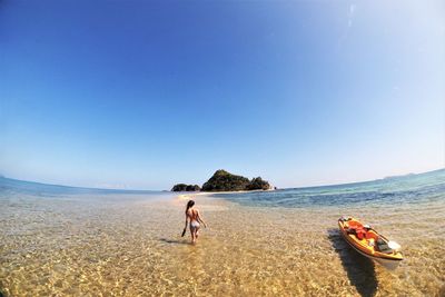 People on beach against clear sky