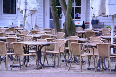 Empty tables and chairs at sidewalk cafe