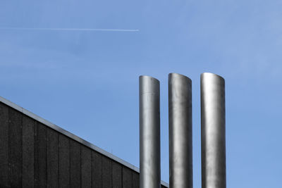 Low angle view of smoke stacks against sky