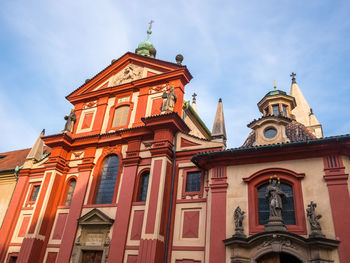 Low angle view of clock tower amidst buildings against sky