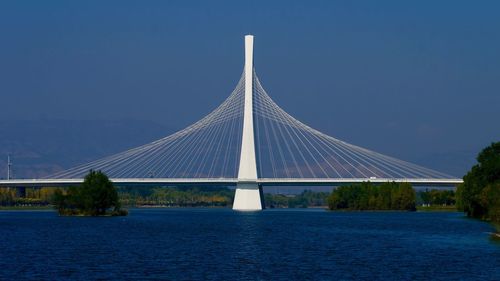 View of bridge over river against blue sky