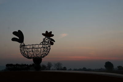 Silhouette of bicycle against sky during sunset