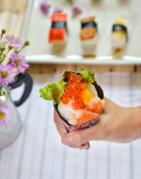 Cropped image of hand holding sushi