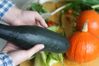 Cropped hand of person holding pumpkin