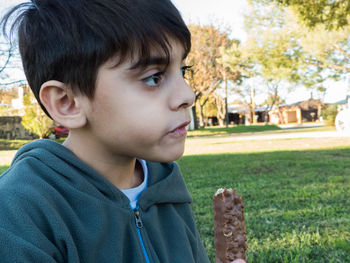 Close-up portrait of boy eating chocolate bar