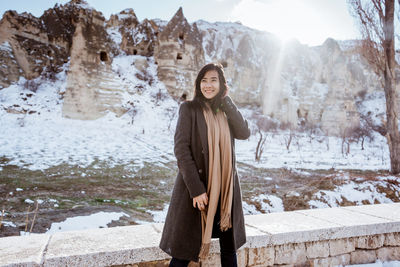 Portrait of young woman standing on snow