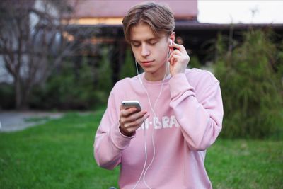 Young woman using mobile phone in field