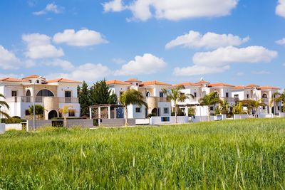 Houses on field against sky