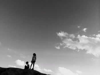 Low angle view of silhouette people standing against sky