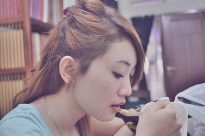 Beautiful young woman having food in restaurant