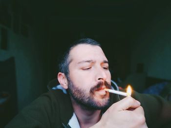 Portrait of man holding burning candle