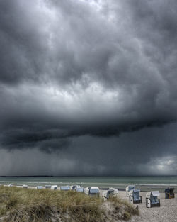 Scenic view of beach against cloudy sky