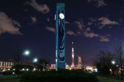 Low angle view of illuminated factory against sky at night