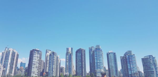 Panoramic view of modern buildings against clear blue sky