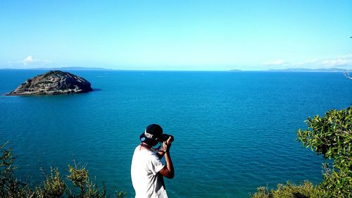 Rear view of man photographing sea