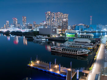 Boats moored at harbor at night