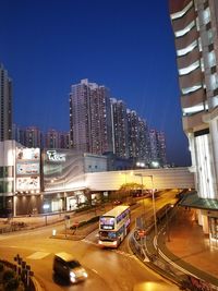 Cars on road in city against clear blue sky