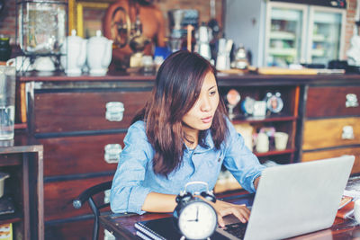 Portrait of woman sitting on table at home