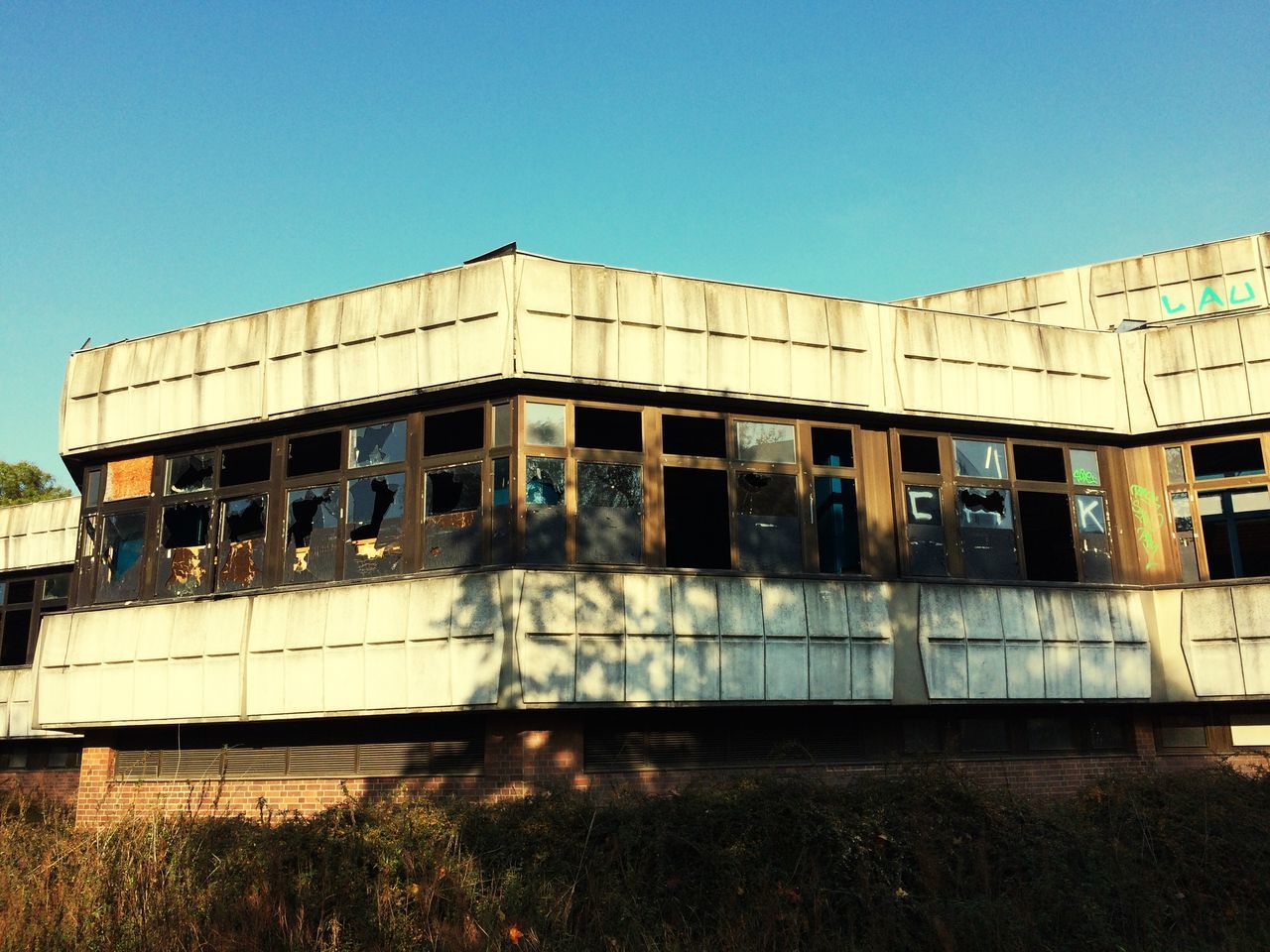 architecture, built structure, building exterior, clear sky, copy space, building, exterior, abandoned, window, sunlight, old, day, outdoors, transportation, blue, facade, house, sky, obsolete, no people