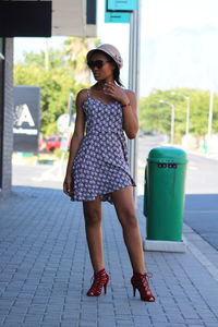 Young woman standing on footpath