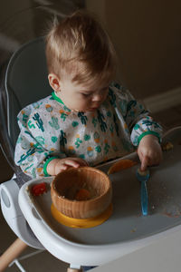 High angle view of cute baby girl sitting on table