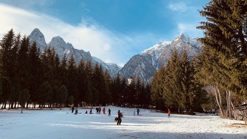 People on snowcapped mountain against sky