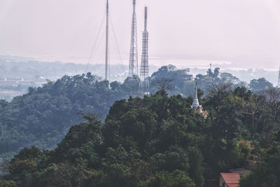 View of trees and buildings against cloudy sky