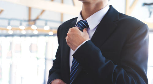 Businessman adjusting his neck tie.