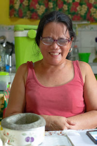 Portrait of smiling woman with tattoo on table